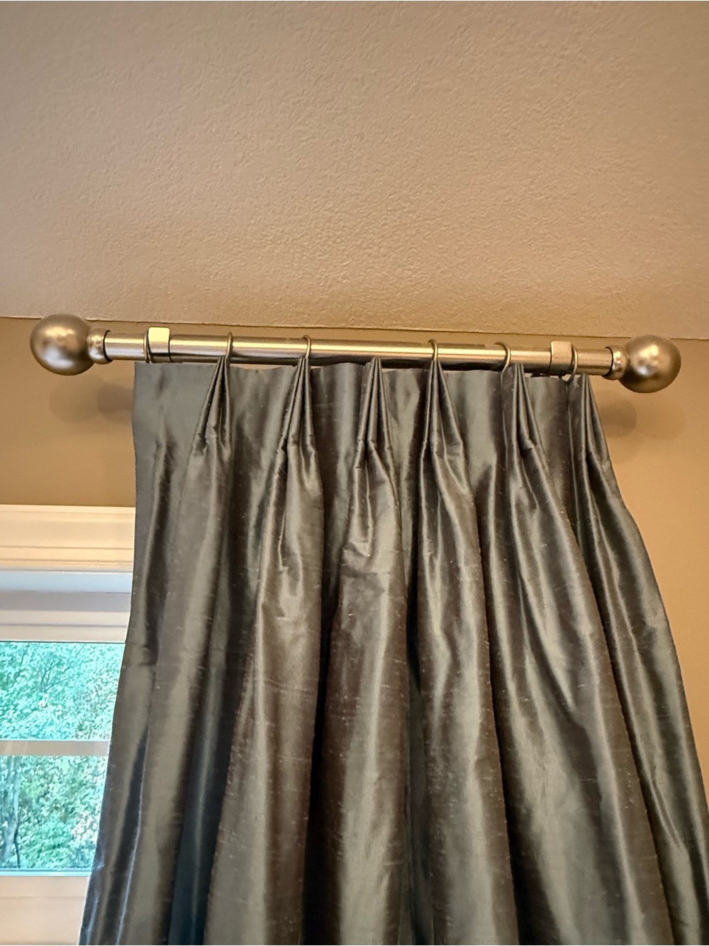 Two blue custom made pinch pleat draperies with silver hanging hardware.
